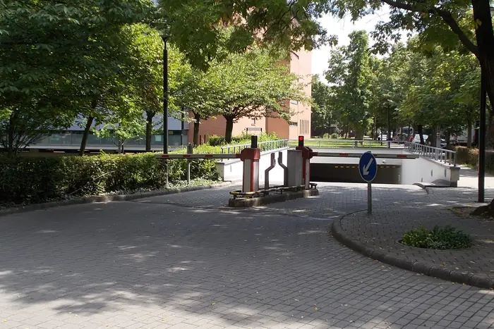 Talanquera de acceso a un parqueadero subterráneo junto a un edificio