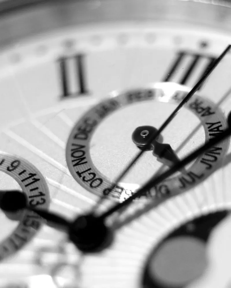 Primer plano en blanco y negro de una esfera blanca con números romanos y fase lunar