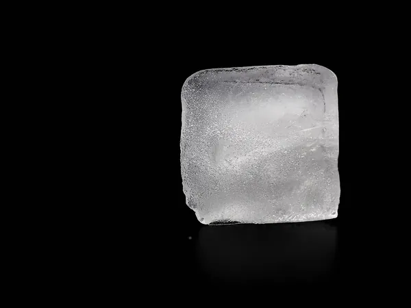 Un cubo de hielo cristalino sobre fondo oscuro