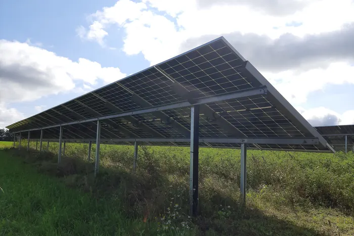 Estructura metálica fija sosteniendo una fila de paneles solares sobre césped