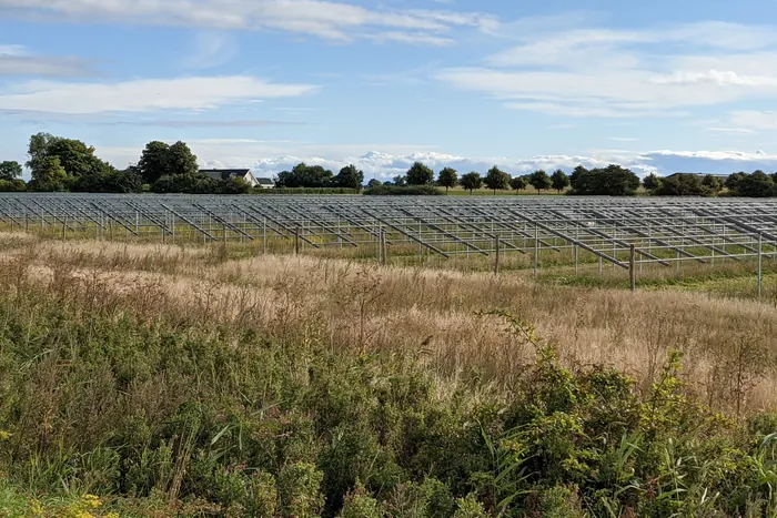 Estructuras metálicas de un sistema solar en suelo durante su construcción, en campo abierto